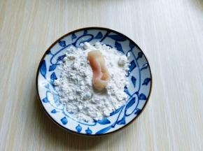 将腌制好的鱿鱼圈放入淀粉中，裹满淀粉。