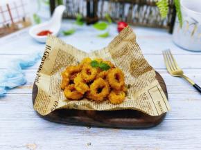 炸好的鱿鱼圈放在油纸上。