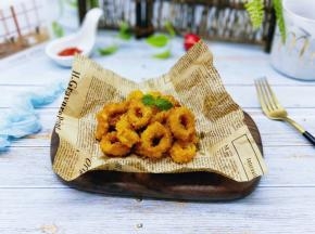 炸好的鱿鱼圈放在油纸上。