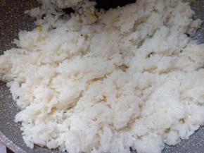 米饭放入锅内，将米饭炒散。