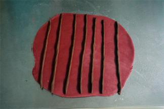 把红色的面团擀成21*22的面片，随意放上棒状的可可面团。