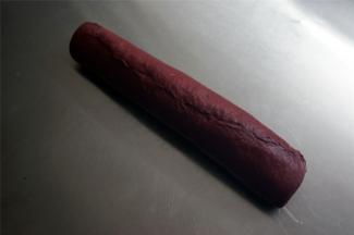 从与棒状可可面团平衡的方向将面团卷起，收口捏紧。