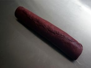 从与棒状可可面团平衡的方向将面团卷起，收口捏紧。