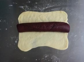 将原色面团擀成21*22的面片，然后将红色面团包裹住。