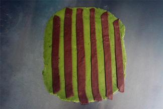 把可可色的条状面片随意摆放在绿色的面片上，然后用擀面杖稍微压一压。