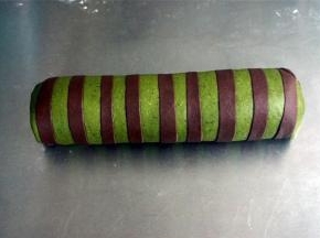 将可可条绿色面片包裹住原色的面团，包裹的方向与可可面条平衡，我图片所示是错误的垂直方向，注意了。因为包好了才发现，只能将错就错了。