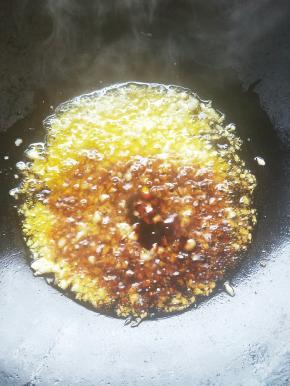 热锅放油，爆香蒜粒。