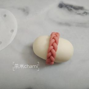 把麻花辫抹少许水，贴到白馒头上。
夏天室温发酵40分钟，冬天烤箱30度发酵40分钟。蒸十分钟。