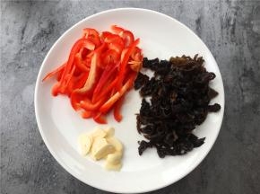 将红椒、黑木耳切丝，大蒜切片。