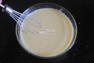 倒入一半的奶液进蛋黄糊里，迅速搅拌均匀，手脚得麻利哦，不然可能底下的鸡蛋液会熟了，那口感就不行了哈。