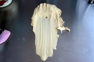 带上无粉橡胶手套，将面团倒到干净的台面上，用掌心向前推搓面团，将面团搓至细腻不粘手为止。