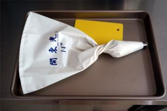 将一小部分的面团装入裱花袋中，裱花嘴是珍妮曲奇8齿菊花嘴。不建议用一次性裱花袋，容易穿。