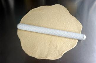 将面团擀开排气，然后卷起。