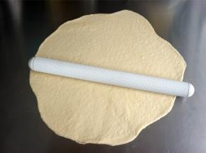 将面团擀开排气，然后卷起。