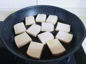 不粘煎锅中加入食用油，再把切好的豆腐依次摆放到锅中。