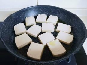 不粘煎锅中加入食用油，再把切好的豆腐依次摆放到锅中。
