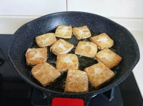 中小火将豆腐煎至金黄，再翻一面，两面都煎至金黄即可。