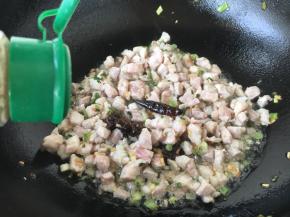 滑炒肉粒至颜色变白色，放入少许的白胡椒粉，翻炒几下。