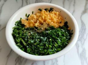 将煎好并切碎的鸡蛋与韭菜混合在器具中，加入盐，糖，十三香搅拌均匀。