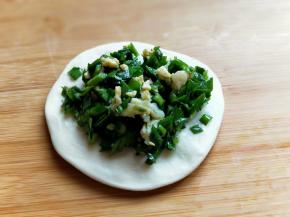 取一块面皮，用擀面杖擀圆，盛一勺馅料。