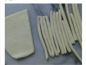 白色的面团擀薄后，切成条状。