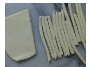 白色的面团擀薄后，切成条状。