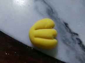 小圆，收圆后，搓成半圆状，压平一下，切出两条线后，在线的位置往里推一推。如图