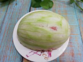 西瓜皮先用盐先搓一遍，然后在用水冲洗干净，然后将西瓜果肉挖出，里面留一点红色部分，用刮刀刮去外面的翠皮