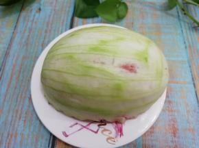 西瓜皮先用盐先搓一遍，然后在用水冲洗干净，然后将西瓜果肉挖出，里面留一点红色部分，用刮刀刮去外面的翠皮