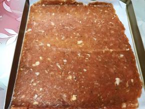 把肉脯连同油纸放入烤盘里，剪去另外一半油纸可以继续利用哦