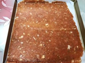 把肉脯连同油纸放入烤盘里，剪去另外一半油纸可以继续利用哦