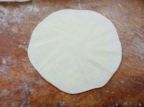 取一个剂子滚圆，压扁，擀成薄皮状（跟擀饺子皮一样样的，只是比饺子皮要薄）