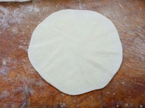 取一个剂子滚圆，压扁，擀成薄皮状（跟擀饺子皮一样样的，只是比饺子皮要薄）