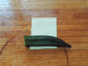 取一张豆皮，将秋葵放置一面
