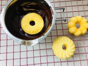 14、	这里以黑巧克力为例，将黑巧克力隔水融化，水温不可超过60度。待巧克力完全融化，且搅拌顺滑后。将甜甜圈正面向下，放入黑巧克力中。