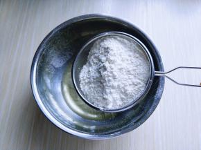 加热的玉米油倒入器具中，筛入低筋面粉。