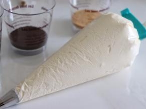 用小刮板辅助把奶油推到前面，扎紧口，这步尽量避免接触到袋子，否则手温容易导致奶油融化。