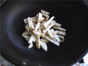 将茄条放入锅中煸制。