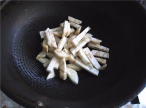 将茄条放入锅中煸制。