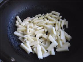 将土豆条放入锅中煸制。