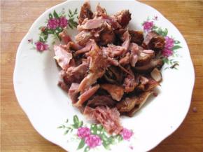 将烤鸭肉拆骨取肉，切成较宽的条备用。