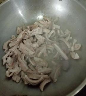 热锅凉油下蒜头，煸炒片刻后倒入猪肚，翻炒均匀。