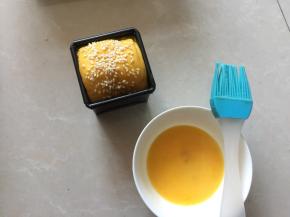 取出发酵好的吐司，在表面上刷上薄薄的蛋黄液，撒上白芝麻
