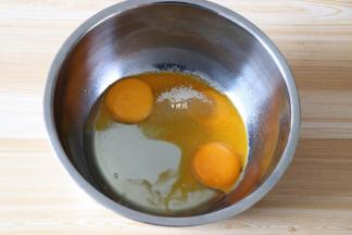 剩余10g白糖倒入蛋黄中，再倒入玉米油，搅拌均匀；