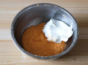 挖三分之一打发好的蛋白到蛋黄面糊中，翻拌均匀；