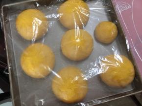 面团一次发酵完成，取出面团，将面团分割成5份，揉成紧实的面团，盖上保鲜膜松弛10分钟
