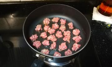 手粘水将牛肉分成小份放入不粘酱上中火煎焦