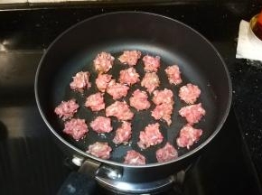 手粘水将牛肉分成小份放入不粘酱上中火煎焦