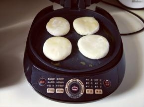 再将包好的韭菜饼放入美的煎烤机中，按馅饼功能。