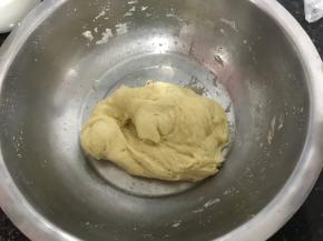 将静置后的面团揉出面筋，分次加入细砂糖，全部揉均匀，细砂糖化开，揉至六七分筋后加入软化的黄油，揉至扩散阶段